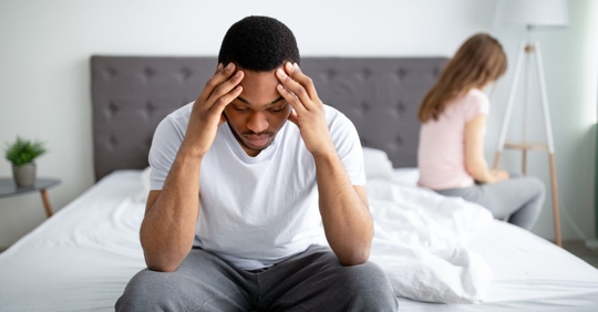 man and woman looking sad in bed